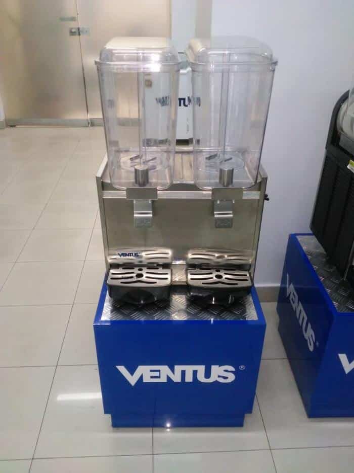 Dispensadora de jugos VJ-182 sobre pedestal en una tienda